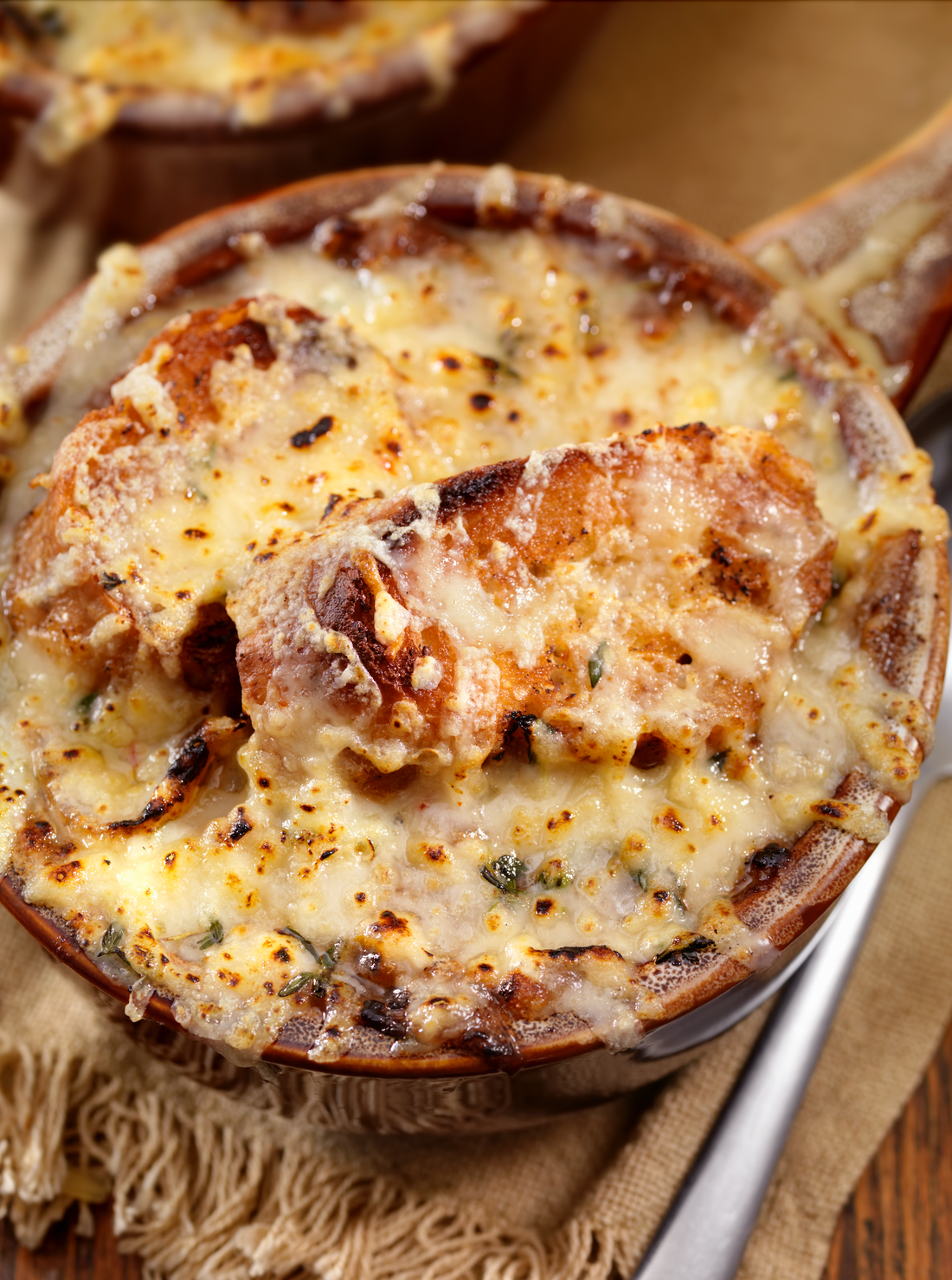 Bowl of French Onion Soup with melted cheese and chives